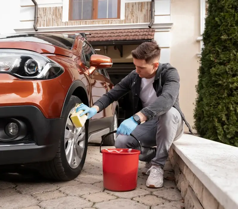 Lavage auto à domicile Montmartin-sur-Mer : professionnel intervenant sur un véhicule